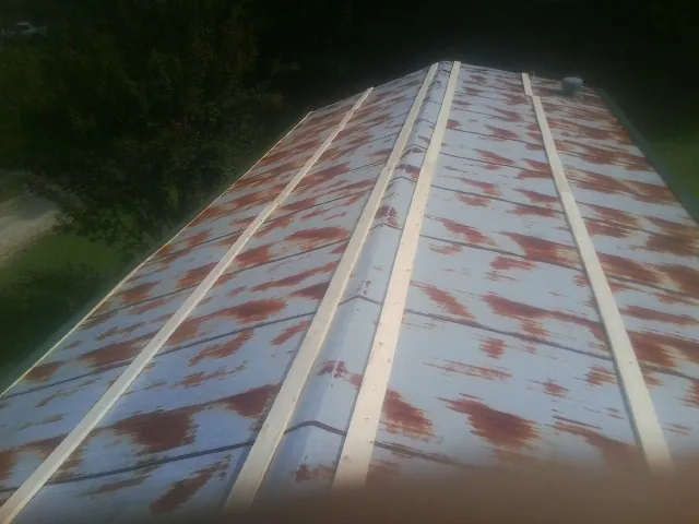 Rusted metal roof panels with new wood purlins before replacement — Storm Damage Roof Repair in Nelliston by Roofing Brothers